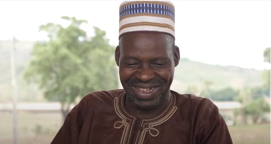 Man smiling wearing traditional African outfit